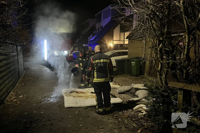 Brandende deken geblust met emmer water