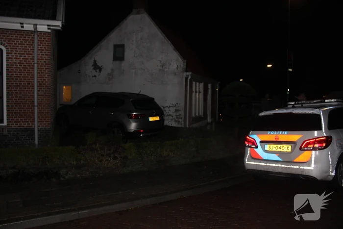 Auto glijdt door tegen woning