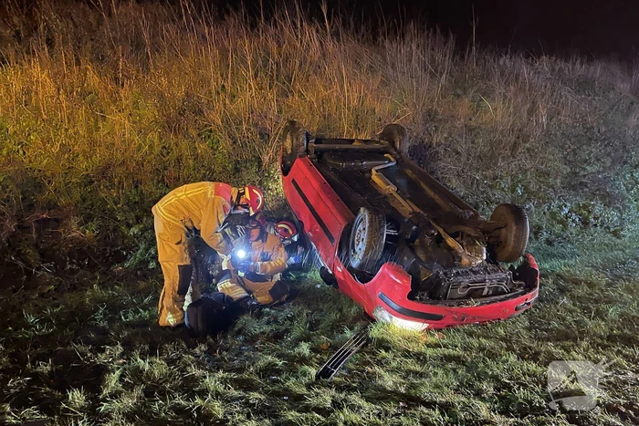 Auto belandt op de kop naast weg