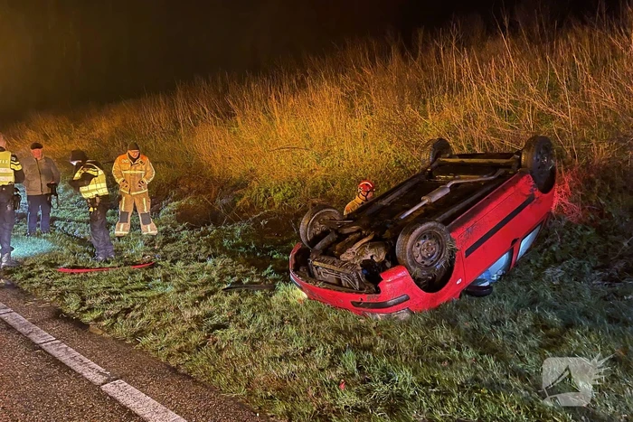 Auto belandt op de kop naast weg