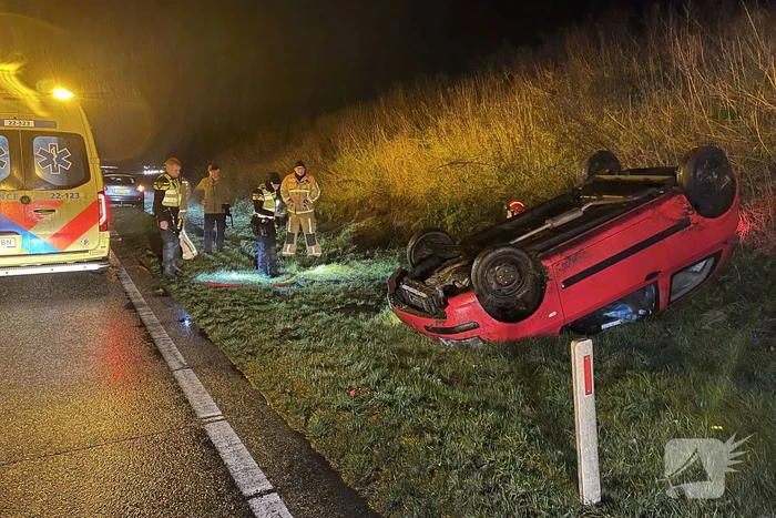 Auto belandt op de kop naast weg