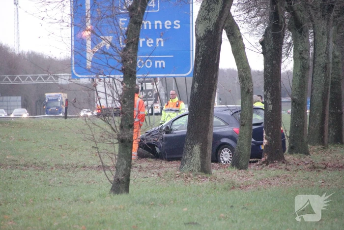 Auto raakt van de snelweg af en knalt tegen boom
