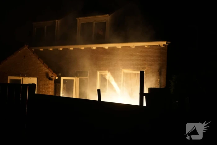 Metershoge vlammen tegen gevel bij buitenbrand