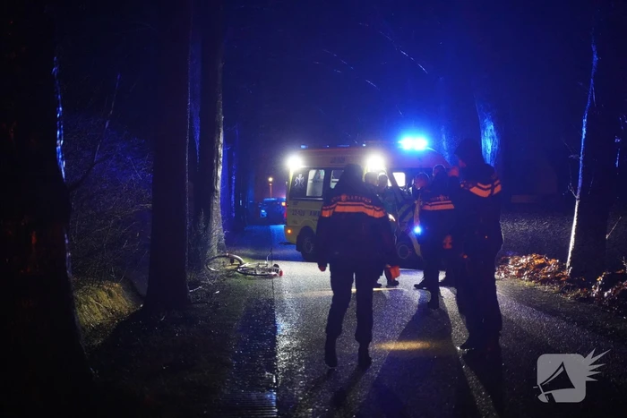 Hulp aan gevallen fietster op donkere weg