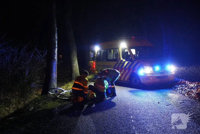 Hulp aan gevallen fietster op donkere weg
