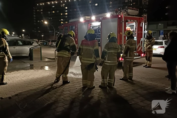 Brandweer blust in brand gestoken container