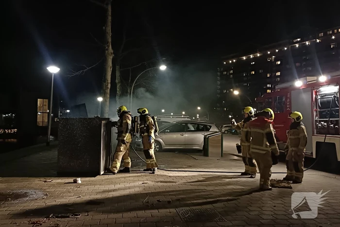 Brandweer blust in brand gestoken container