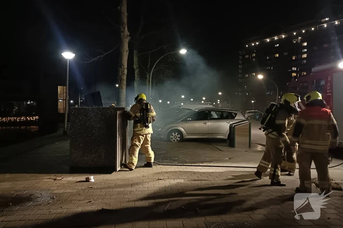 Brandweer blust in brand gestoken container
