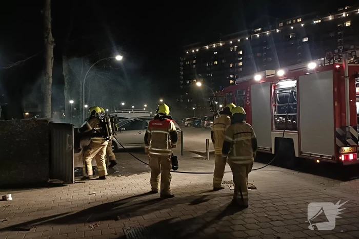 Brandweer blust in brand gestoken container