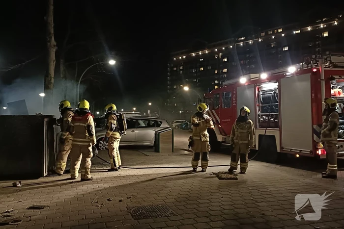 Brandweer blust in brand gestoken container