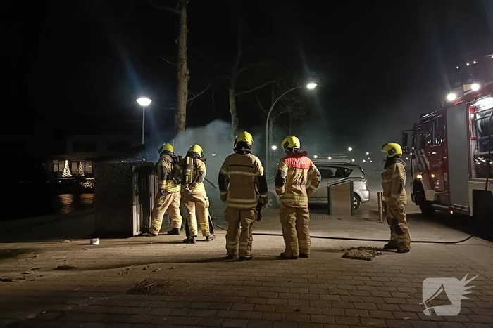 Brandweer blust in brand gestoken container