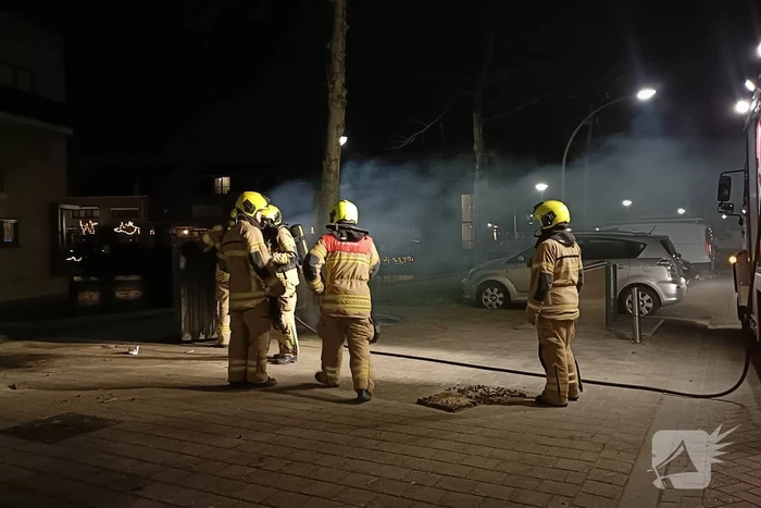 Brandweer blust in brand gestoken container