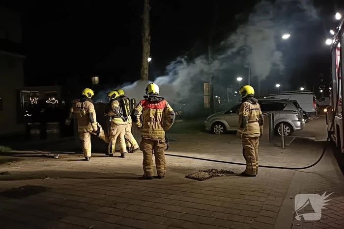 Brandweer blust in brand gestoken container