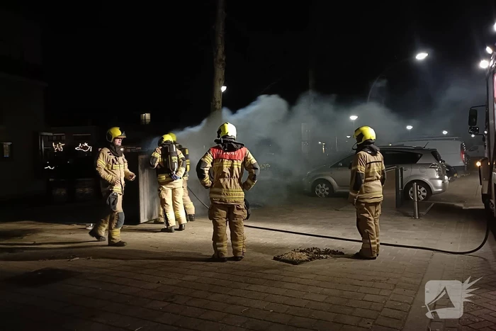 Brandweer blust in brand gestoken container