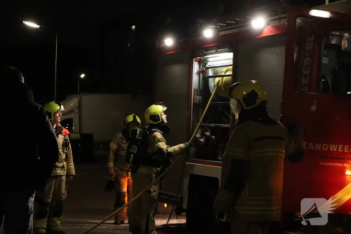 Brandweer blust brandende papiercontainer