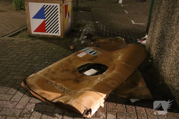 Brandweer blust brandende papiercontainer