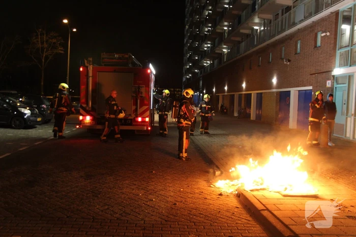 Brandweer blust brandend afval