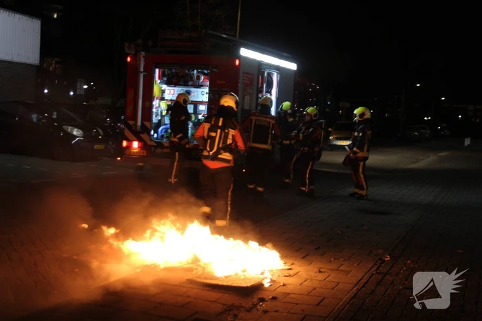 Brandweer blust brandend afval