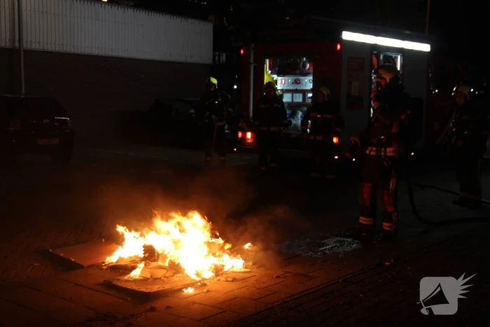 Brandweer blust brandend afval