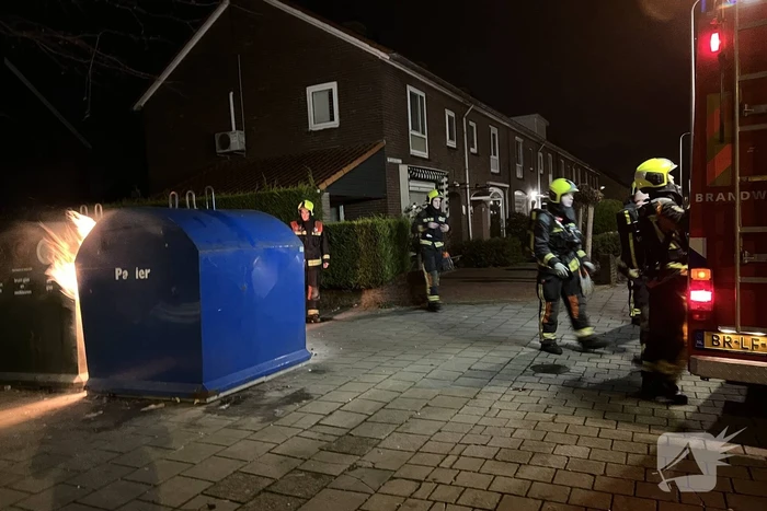 Brandweer blust rotzooi tussen containers
