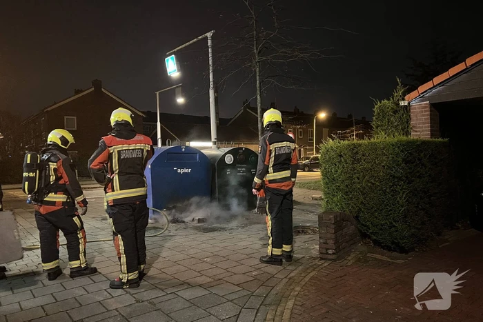 Brandweer blust rotzooi tussen containers