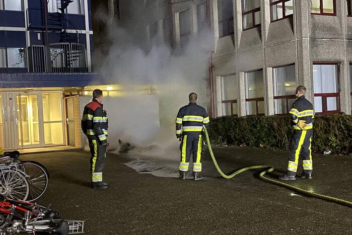 Container in brand tegen gebouw