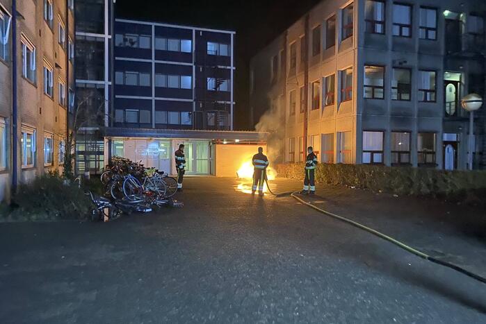 Container in brand tegen gebouw