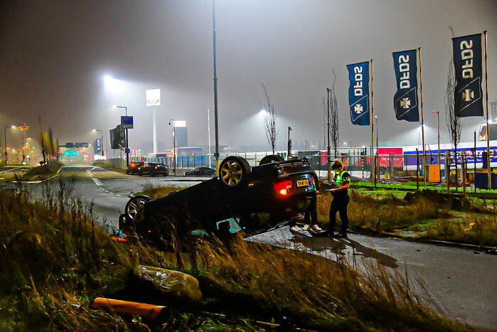 Auto vliegt uit de bocht en belandt op op zijn kop