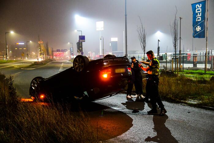 Auto vliegt uit de bocht en belandt op op zijn kop