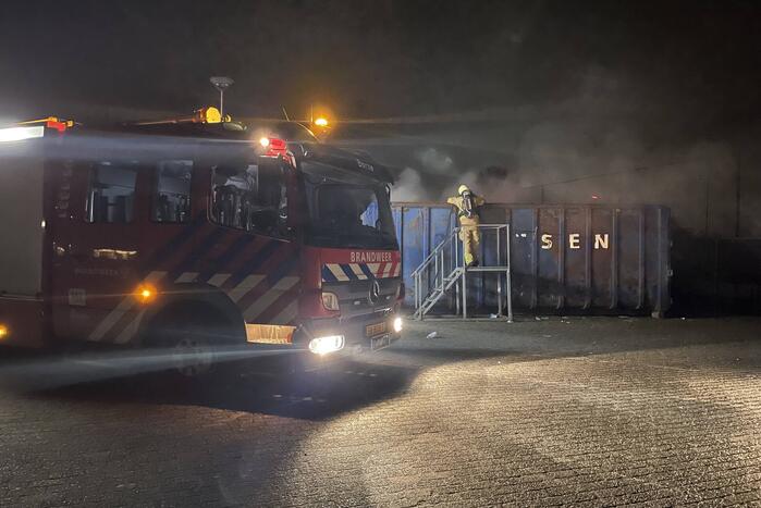 Brandweer blust brand in papiercontainer