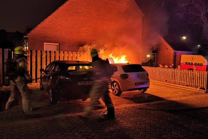Auto en schutting in brand
