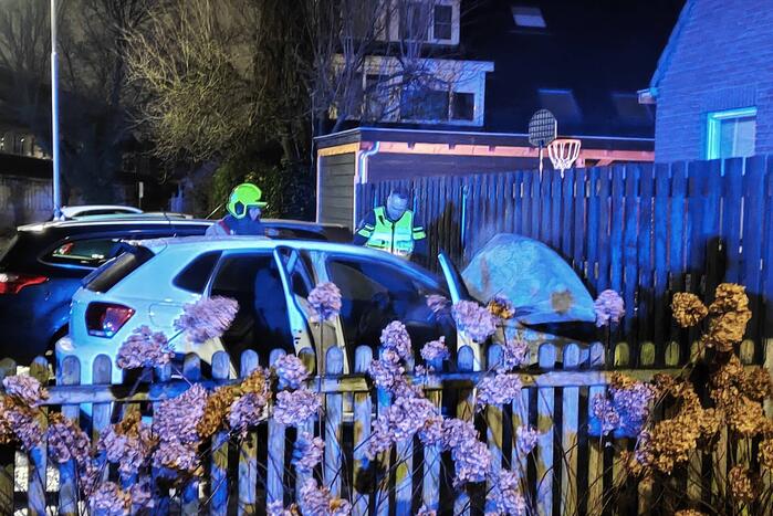 Auto en schutting in brand