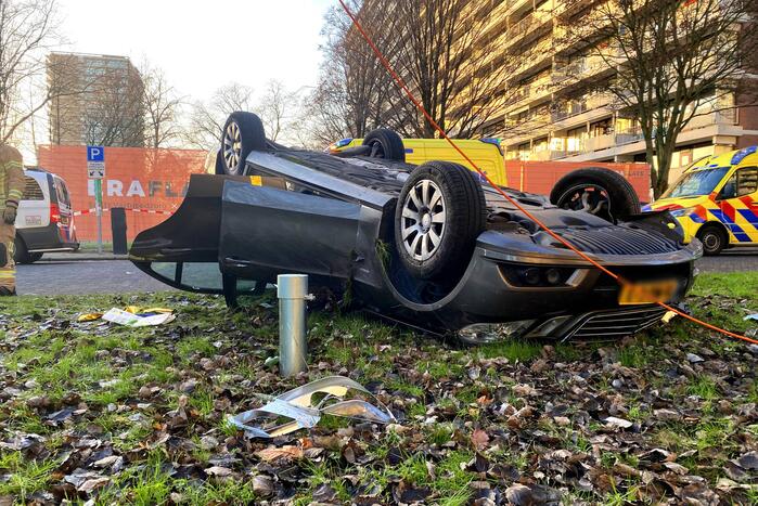 Auto ramt lantaarnpaal en slaat over de kop