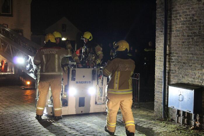 Brandweer veegt schoorsteen na brand