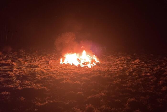 Brandweer blust brandende hoop afval