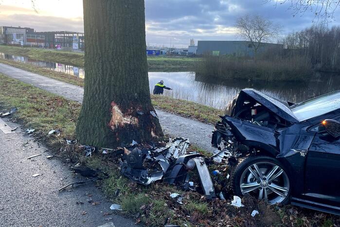Auto ligt in de kreukels na flinke klap tegen boom
