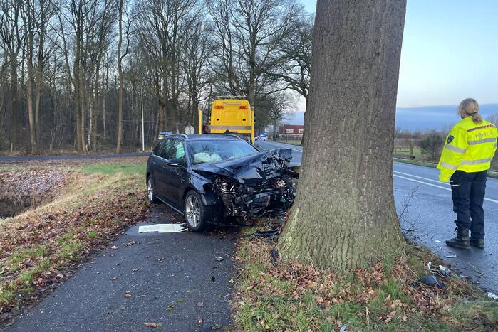 Auto ligt in de kreukels na flinke klap tegen boom