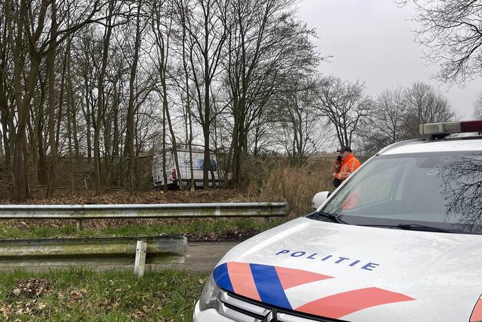 Bestuurder bestelbus raakt van de weg en belandt in bosschage