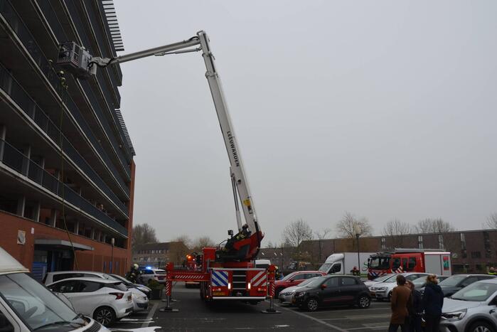 Zwarte rookwolk bij brand in flatwoning