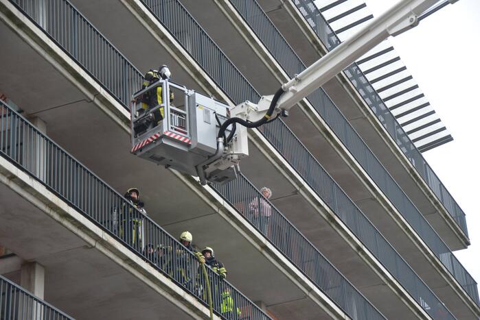 Zwarte rookwolk bij brand in flatwoning