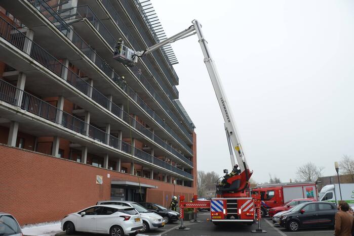 Zwarte rookwolk bij brand in flatwoning