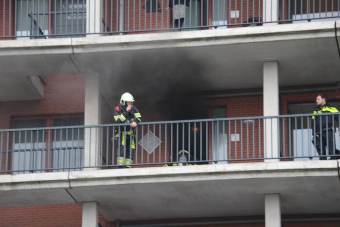 Zwarte rookwolk bij brand in flatwoning