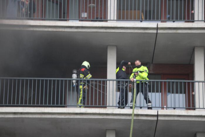 Zwarte rookwolk bij brand in flatwoning