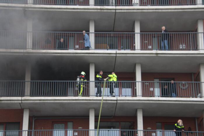 Zwarte rookwolk bij brand in flatwoning