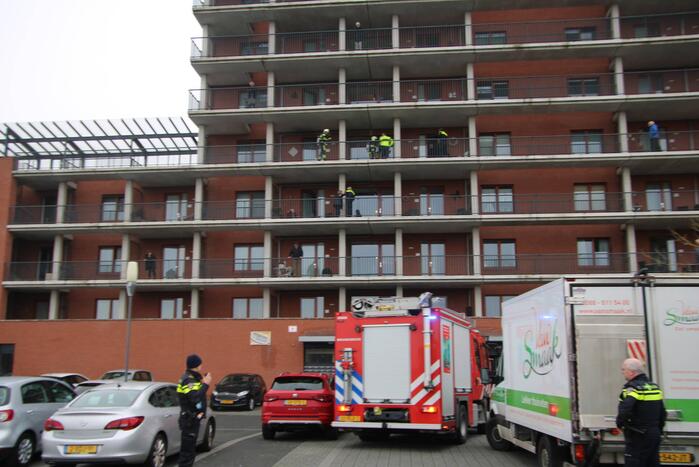 Zwarte rookwolk bij brand in flatwoning