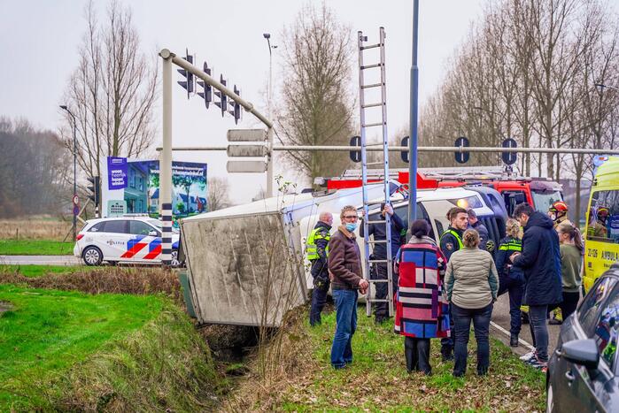 Bestelbus kantelt en belandt in sloot