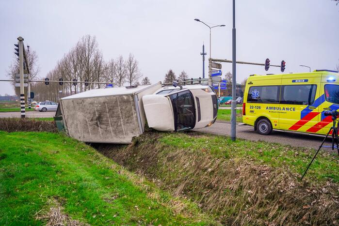 Bestelbus kantelt en belandt in sloot