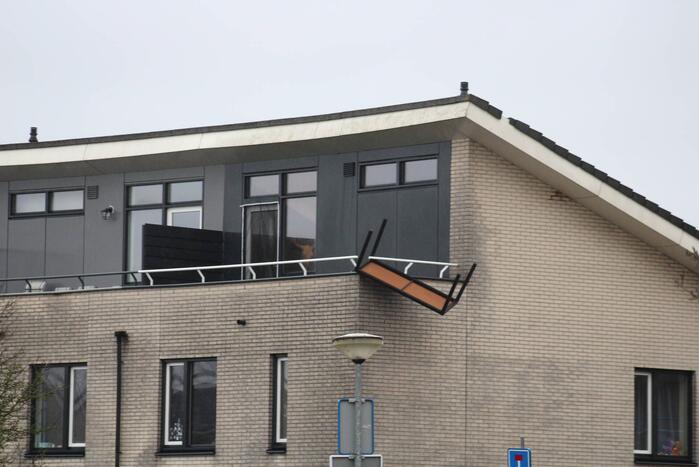 Weggewaaide tafel hangt gevaarlijk over balkonrand