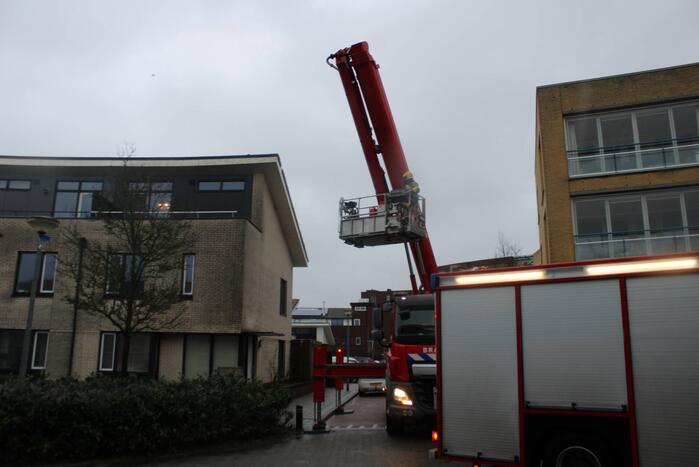 Weggewaaide tafel hangt gevaarlijk over balkonrand