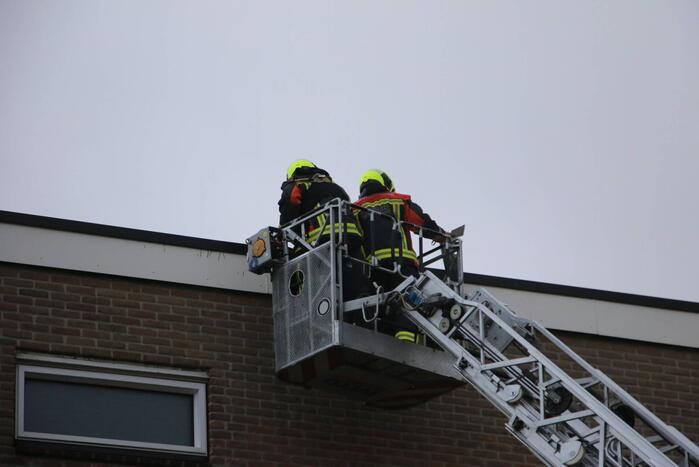 Brandweer verwijderd bevestigingsmateriaal van dak